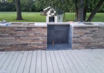 DECK & OUTDOOR KITCHEN - Large country deck, outdoor kitchen with 36 inch cooktop, sink, stone facade, concrete countertop and slate grill enclosure under construction